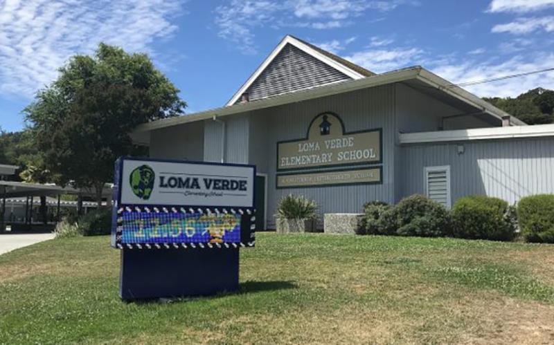 front of loma verde school with sign